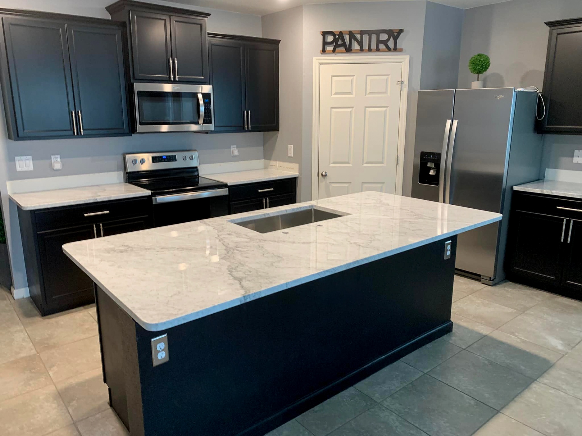 Dark cabinet kitchen with white marble island