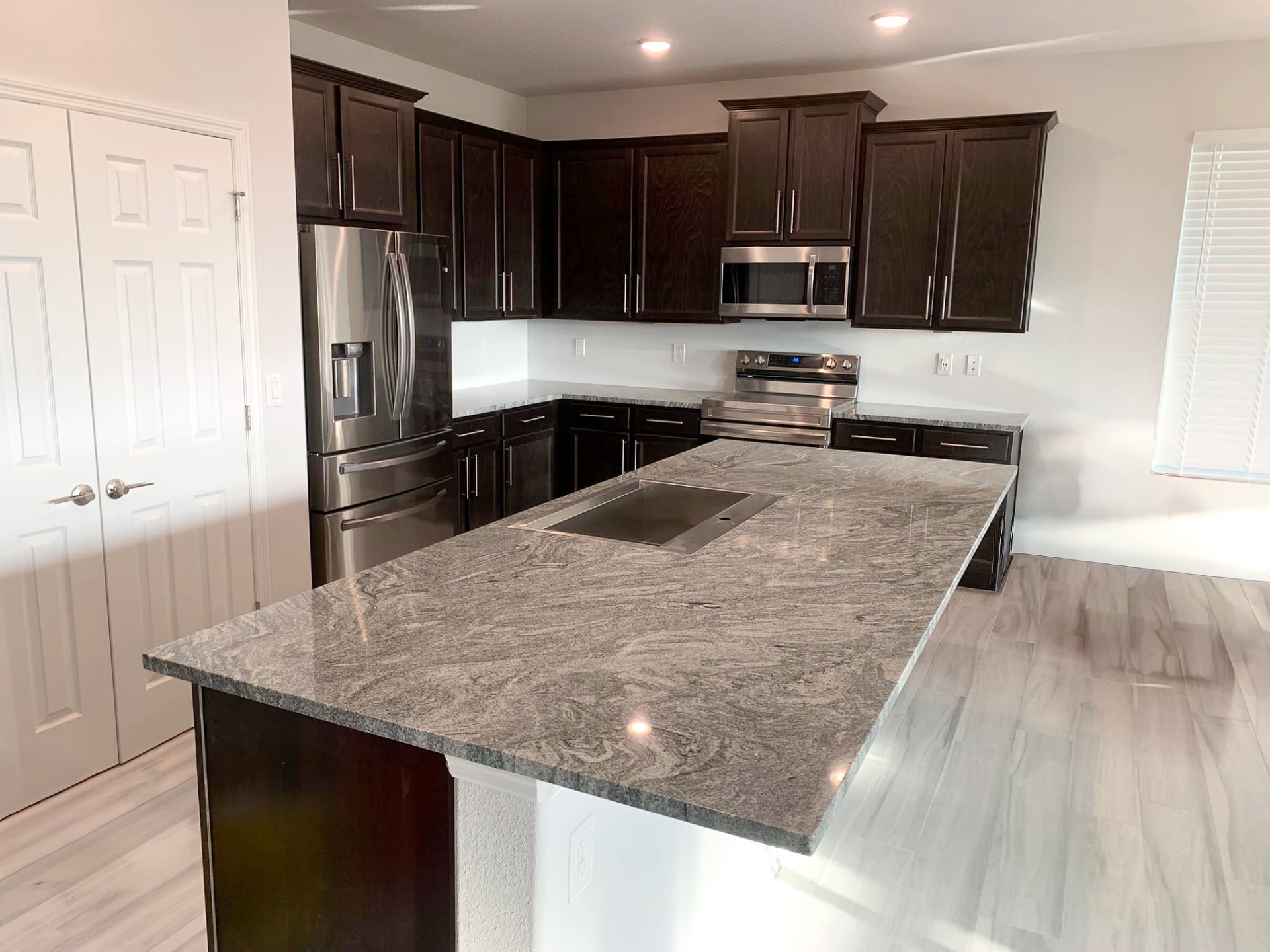 Kitchen remodel with granite island and dark shaker cabinets